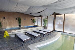 a pool with a row of chairs in a building at Апартамент Борчето Forest Glade- Pamporovo in Pamporovo