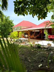 a house with a red roof at Villa Les Bougainvilliers in Capesterre-de-Marie-Galante