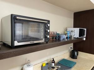 a microwave sitting on a shelf above a kitchen counter at Loft Full Amenities en Retiro in Buenos Aires