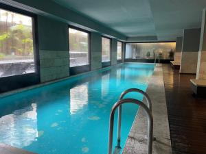 a swimming pool with a chair in a building at Loft Full Amenities en Retiro in Buenos Aires