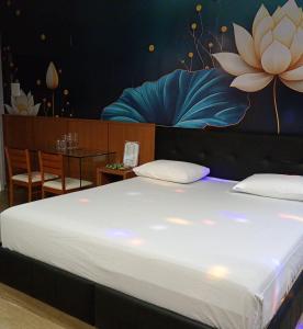 a bedroom with a large bed with a painting on the wall at STILLUS - Hotel e Motel in Imperatriz