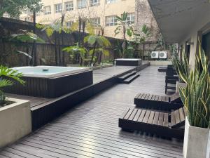 a deck with benches and a tub in a courtyard at Loft Full Amenities en Retiro in Buenos Aires