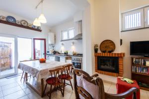 a kitchen with a table and chairs and a fireplace at Casa do Pisco - by Smarthomes in São Martinho do Porto