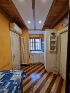 ジェノヴァにあるPontedecimo Apartment Twoの黄色い壁と木の床と窓のある部屋