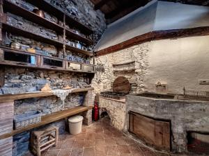 a kitchen with a stove and a stone wall at The Historic Oil Mill- Romantic Retreat in Alassio +24 photos