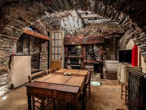 a dining room with a table and a stone wall at The Historic Oil Mill- Romantic Retreat in Alassio