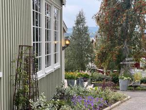 a house with a garden with flowers and a window at Hotell Åre Fjällsätra in Undersåker