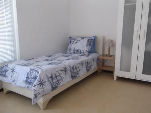 1 dormitorio con 1 cama con edredón azul y blanco en Apartment Sredna Gora, en Burgas