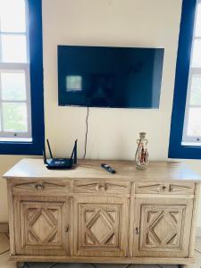 a wooden cabinet with a television on top of it at Cantinho Pilar in Ouro Preto