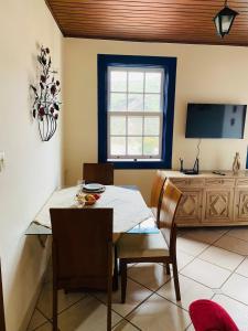 a dining room with a table and chairs and a television at Cantinho Pilar in Ouro Preto