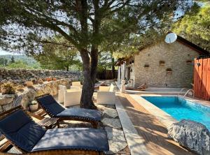 a pool with chairs and a tree next to a building at Kuća za odmor Brigitaa in Jezera