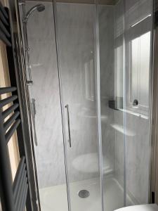 a shower with a glass door in a bathroom at Bliss on the Bay at Waterside Holiday Park in Paignton