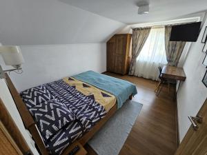 a bedroom with a bed and a television in it at Casa In Curte La Zavate in Bran