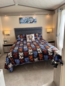 a bedroom with a bed with a colorful comforter at Bliss on the Bay at Waterside Holiday Park in Paignton