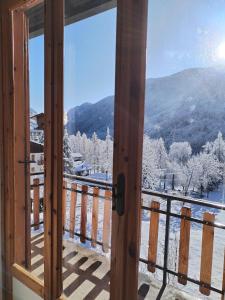 uitzicht op een besneeuwde berg vanuit een raam bij Castori 1 in Prazzo