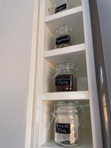 a refrigerator with two jars of food in it at Quiet and Central, Modern Bungalow in Hereford