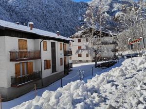 een gebouw bedekt met sneeuw naast een berg sneeuw bij Castori 1 in Prazzo