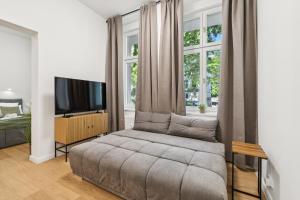 a living room with a couch and a tv at Modern Apartment in Berlin in Berlin
