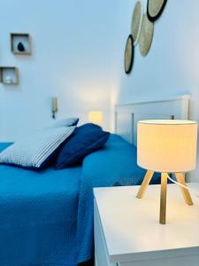 a blue bedroom with a bed and a table with a chair at Da Liliana Apartment in Mazara del Vallo