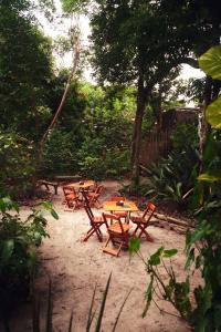 a group of wooden tables and chairs on the sand at Taba Maraú in Marau
