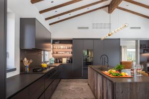 a kitchen with black cabinets and a counter top at Villa Cypress Hill in Motovun