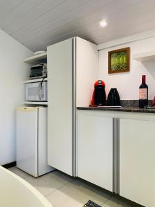 eine Küche mit weißen Schränken und einem Kühlschrank in der Unterkunft Cantinho Familia in Ouro Preto + 17 Fotos