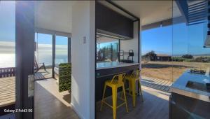 a kitchen with a counter and a view of the ocean at Tiny House El PANGAL in Cáhuil