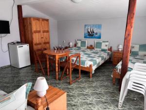 a room with a bed and a table and a bed and a table and chairs at Guest House Nikolovi in Lozenets