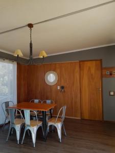 a dining room with a wooden table and chairs at El Jardín de la Sierra in Villa Serrana +59 photos
