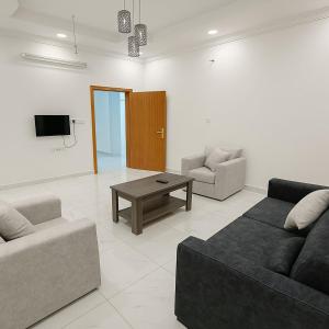 a living room with two couches and a coffee table at منازل الباحة للشقق الفندقية in Al ‘Āmirah