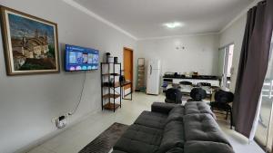 a living room with a couch and a flat screen tv at Casa Aconchegante, 8 pessoas, 2vagas grandes in Maringá