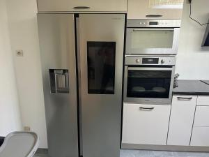 a kitchen with a refrigerator and an oven at Maison Serenity Domont Retreat in Domont