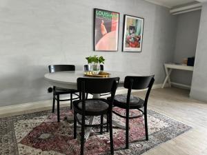 a dining room with a table and chairs on a rug at Charmigt i centrala Ystad in Ystad +4 photos