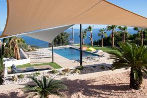 a large white umbrella over a swimming pool at Villa 5 BDs Breathtaking Views Large Pool Jacuzzi in Carqueiranne