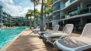 Una fila de tumbonas junto a una piscina. en Las Olas - Luxury apartment in Palm-Mar, en Palm-mar