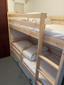 Litera de madera con almohadas en Le studio des oursons, en Auris
