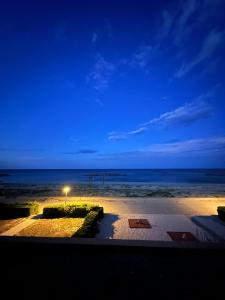 a view of a beach at night with a street light at Front de mer - Le Barcarès in Le Barcarès +10 photos