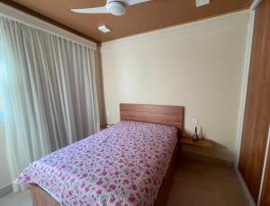 a bedroom with a bed with a purple bedspread at Casa condominio Aldeiá de jacuipe in Barra de Jacuípe