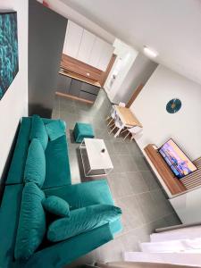 Blue Sapphire by Adriatic Living في Shkallnur: غرفة معيشة مع أريكة خضراء وطاولة