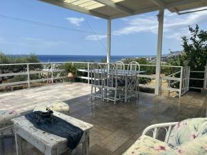a patio with a table and chairs and the ocean at Villa Evdokia II in Makry Gialos