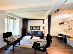 uma sala de estar com um sofá, cadeiras e uma mesa em Modern and comfortably furnished apartment em Robertville