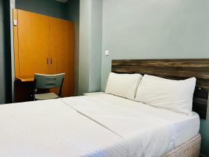 a bedroom with a large white bed and a chair at Libertad 45 in Torrejón de Ardoz