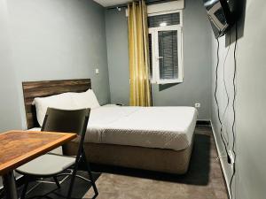 a bedroom with a bed and a table and a desk at Libertad 45 in Torrejón de Ardoz