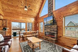 a living room with a fireplace and wooden walls at Hickory Haven By Avada Properties in Gatlinburg