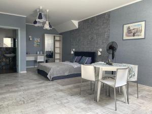 a bedroom with a bed and a table and chairs at Chayka Home Hotel in Chayky