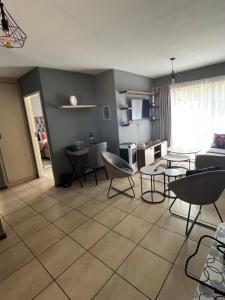 een woonkamer met stoelen en tafels en een keuken bij 2 Spacious bedroom apartment in Lephalale +11 foto's