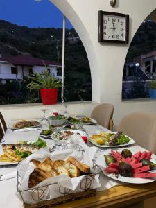 a table with plates of food on it with a clock at Guest house Irvin in Berat