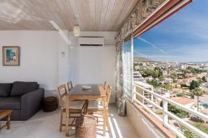 Una habitación con una mesa y sillas y una ventana grande. en Azul Horizonte with a pool, en Benalmádena
