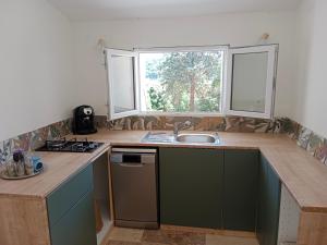 a kitchen with a counter and a sink and a window at Chez Marguerite in Labastide-de-Virac