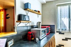 a kitchen with a stove and a microwave at Appartement dans le centre médiéval in Hyères